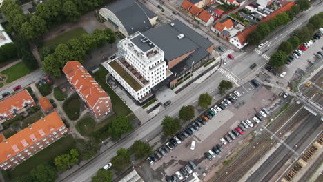 Fritiden-hotel-in-Ystad-city-near-railway-tracks,-aerial-drone-motion-view