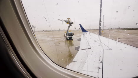 De-Icing-Truck-Prepares-to-Spray-Airplane-Wing-While-Sitting-On-Runway