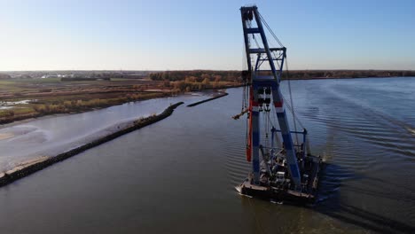 Aerial-Circle-Dolly-Around-Forward-Bow-Of-Matador-Floating-Crane-Being-Guided-By-Tug-Boat-Along-Oude-Maas