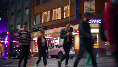 People-Walking-In-The-Street-At-Night-With-Traffic-In-Sydney,-NSW,-Australia