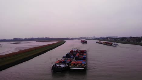 Luftaufnahme-Des-Maas-frachtschiffes-Gepaart-Mit-Einem-Anderen-Transportcontainer-Auf-Dem-Fluss-Noord-Am-Bewölkten-Nachmittag