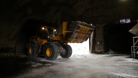 Road-Salt-Chemical-Bucket-Loader-dumps-A-Load-of-product-into-a-conveyor-elevator-In-Dry-Storage-before-it-goes-to-a-truck-at-a-port-on-a-river-stock-video-footage-#3