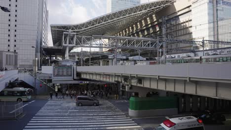 Osaka-JR-Umeda-Station,-Train-Arriving-While-People-Wait-at-Cross-Walk