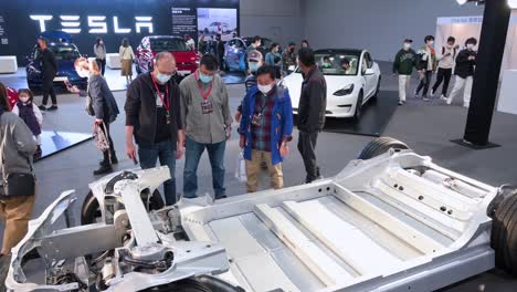 Besucher-Sehen-Und-Testen-Ein-Tesla-fahrgestell-Und-Einen-Fahrzeugrahmen-Eines-Kraftfahrzeugs-Während-Der-International-Motor-Expo,-Auf-Der-Ev-elektroautos-In-Hongkong-Präsentiert-Werden