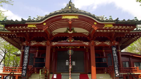 Asakusa,-Tokio,-Japón-Alrededor-De-Abril-De-2020:-Hombre-Caminando-Para-Rezar-En-El-Templo-Japonés-Tradicional,-Enfoque-De-árbol-Verde-Fresco-En-Un-Jardín-Tranquilo-Y-Tranquilo-De-Estilo-Zen-En-Un-Soleado-Día-De-Primavera