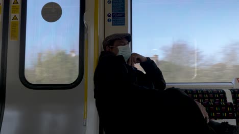 View-Of-Elderly-Adult-Male-Sleeping-On-S8-Stock-Metropolitan-Line-Wearing-Face-Mask-And-Flat-Cap