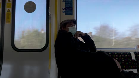 Vista-De-Un-Hombre-Adulto-Mayor-Durmiendo-En-La-Línea-Metropolitana-De-Stock-S8-Con-Mascarilla-Y-Gorra-Plana