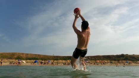 Junge-Im-Meerwasser-Springt,-Um-Den-Vom-Strand-Getretenen-Ball-Zu-Retten