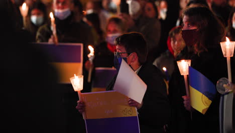Menschen-In-Masken-Mit-Kerzen-Und-Ukrainischen-Fahnen-Während-Der-Gebetswache-Für-Den-Frieden-In-Der-Ukraine-Nachts-In-Leiria,-Portugal