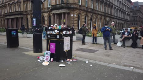 People-walk-past-an-overflown-public-bin