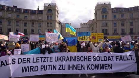 Menschen-Drücken-Ihre-Unterstützung-Für-Die-Ukraine-Bei-Einer-Anti-Kriegs-Demo-In-München-Aus,-Nachdem-Russland-In-Die-Ukraine-Einmarschiert-Ist