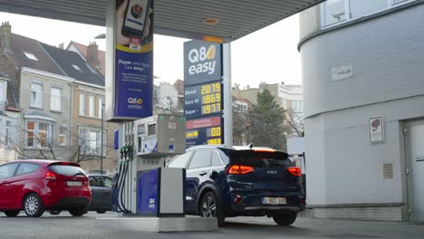 Interaktives-Schild-Mit-Allzeit-Hohen-Gaspreisen-An-Der-Q8-Easy-Tankstelle,-Wenn-Autos-Fahren-Und-Abfahren