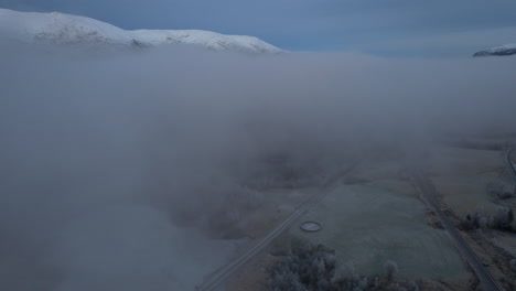 Flying-over-a-foggy-covered-fields-in-Northern-Norway-,-Helgeland,-Blåfjelldalen,-Flyover-drone-shot-into-fog