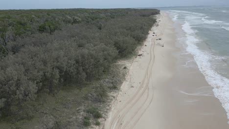 Drone-Flying-Over-North-Stradbroke-Island-In-Queensland,-Australia-With-Woman-Having-Fun-At-The-Beach-In-Summer