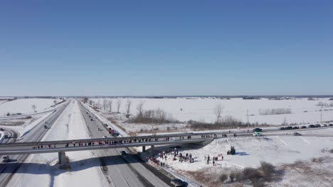 Retroceso-Aéreo-Muestra-Protestando-A-La-Gente-Reunida-Para-Apoyar-El-Convoy-De-Libertad-En-El-Paso-Elevado-En-La-Autopista-417-Cerca-De-Cownall-Ontario