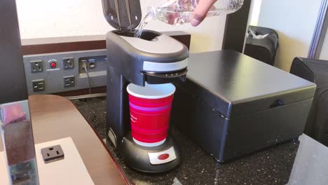 Man-pouring-water-in-coffee-maker-machine-and-turning-it-on-to-make-a-coffee-for-breakfast-in-the-morning-video-background-in-4K-|-Coffee-making-in-coffee-maker-machine