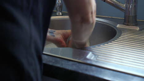 A-woman-washing-dishes-by-hand-up-close-shot