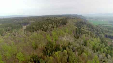 Aerial-drone-shot-of-Hřebeč,-near-town-Moravská-Třebová-and-town-Koclířov-with-dense-green-forest-on-a-cloudy-day-across-rural-countryside-in-Czech-Republic