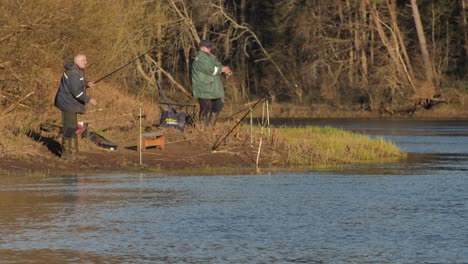 Two-anglers-catch-fish-by-the-river