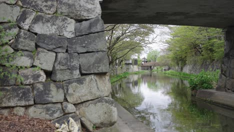 Ancient-Stone-Walls-of-Omihachiman-Canal-in-the-Spring,-Shiga-Japan