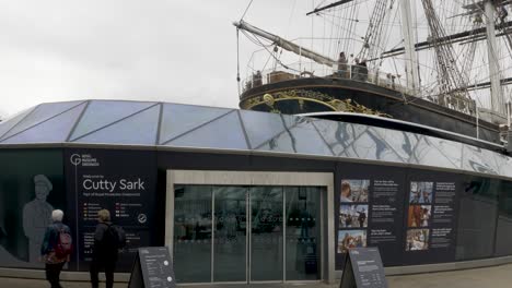 Entrance-to-the-Cutty-Sark-Royal-Museum,-a-famous-Victorian-Tea-Clipper-sailboat-built-for-the-China-Tea-trade-and-now-a-popular-tourist-attraction-in-Greenwich,-London