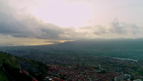 Aerial-drone-forwarding-shot-of-Palermo-city-on-the-foothills-of-a-mountain-range-along-with-mediterranean-sea-coast-from-city-Monreale,-Sicily,-Italy-on-a-cloudy-day
