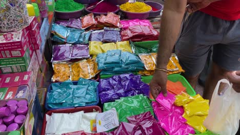 Puesto-De-Venta-De-Pintura-En-Polvo-De-Colores-Para-El-Festival-Hindú-De-Holi-En-Un-Mercado-Lleno-De-Gente-En-Kolkata,-Bengala-Occidental,-India