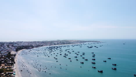 Beautiful-life-of-fisherman-town-Mui-Ne-in-Vietnam-with-many-moored-boats,-aerial-ascend-view