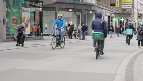 Mensajero-De-Deliveroo-Conduciendo-En-Una-Concurrida-Calle-De-La-Ciudad-Entregando-Pedidos-A-Los-Clientes---Bruselas,-Bélgica