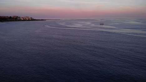 Sailboat-Sailing-In-The-Vast-Ocean-During-Sunset-In-Costa-Del-Sol,-Estepona,-Spain