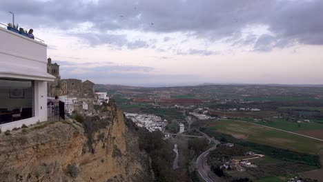 People-on-balcony-overlooking-Spanish-countryside-at-dusk