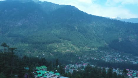 Vista-Aérea-De-La-Ciudad-De-Manali-En-India-Desde-La-Montaña,-Toma-Aérea-Del-Bosque-De-Pinos-De-Manali