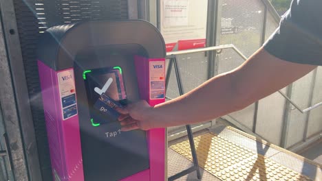 Faceless-male-hand-tapping-on-the-ticketing-machine-to-touch-on-and-off-with-go-card-to-pay-the-fares-of-the-trip-at-the-station,-Brisbane-Queensland-Australia