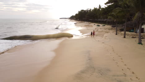 Vorderansicht-Eines-Paares,-Das-An-Einem-Verschwindenden-Strand-Spazieren-Geht,-Mit-Georöhren-In-Beweisen-Vietnam