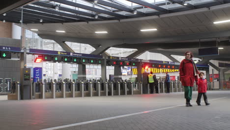 Madre-E-Hijo-Entrando-En-Una-Moderna-Estación-De-Tren-Británica