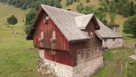 Romantisches-Bauernhaus-Aus-Holz-In-Den-Schweizer-Bergen,-Luftdrohnenflug