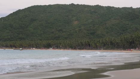 Zeitlupenaufnahme-Von-Kleinen-Wellen,-Die-An-Einem-Langen-Strand-Mit-Palmen-Auf-Den-Philippinen-Angespült-Werden