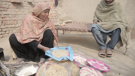 Eine-Dame-Bereitet-Punjab-küche-Zu,-Während-Ein-Mann-Geduldig-In-Einem-Dorf-In-Pakistan,-Punjab,-Wartet