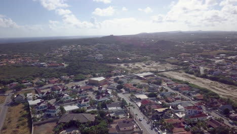 Aerial-pedestal-up-and-pan-of-houses-in-Aruba-with-Hooiberg-mountain-in-the-background