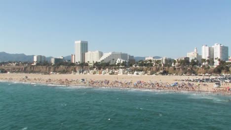 Eine-Schöne-Küstenaufnahme-Des-Berühmten-Strandes-Von-Santa-Monica-Mit-Vielen-Strandbesuchern,-Die-Den-Sommer-Genießen