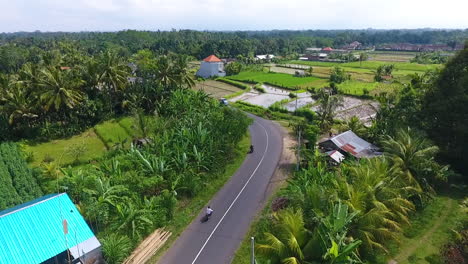 Following-a-motorcycle-across-the-curving-roads-of-Bali,-Indonesia