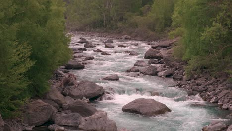 Blick-Stromaufwärts-Auf-Einen-Klaren-Blauen-Fluss-Voller-Wasser-Und-Felsen,-Der-Durch-Die-Wildnis-Fließt