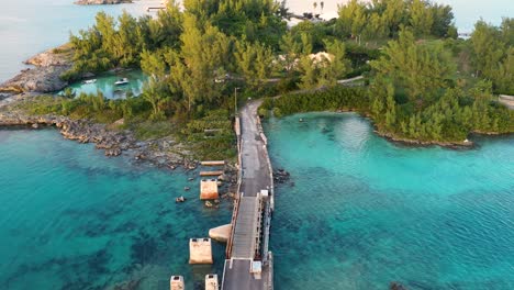 Aerial-view-of-small-bridge-over-clear-turquoise-water-on-tropical-island