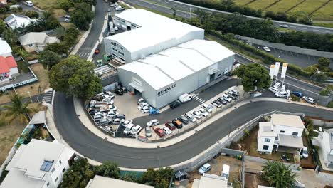 Aerial-drone-flight-over-a-Renault-car-dealership-and-repair-centre-in-Saint-Pierre,-Reunion-Island