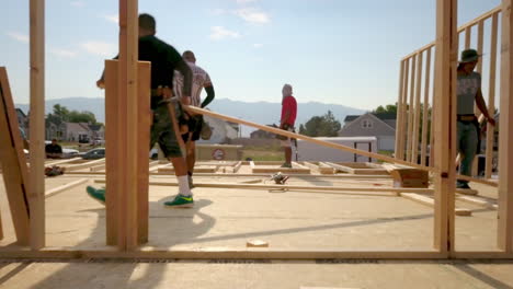 Ein-Drohnenschuss,-Der-Sich-Langsam-Von-Einem-Bauarbeiter-Zurückzieht,-Der-Wände-Für-Ein-Neues-Haus-Errichtet,-Das-Gerade-Gebaut-Wird