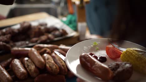 SLOWMO---Putting-barbeque-sauce-on-plate-with-sausages,-steaks-and-grilled-corn