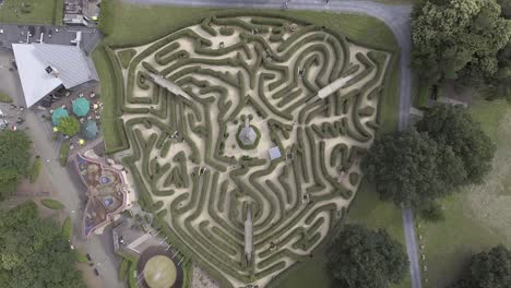 A-top-down-drone-shot-from-a-big-maze-in-the-Netherlands,-with-people-walking-inside-the-maze