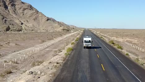 Aéreo,-Marcha-Atrás,-Disparo-De-Drone,-Frente-A-Una-Autocaravana,-Camión,-Conduciendo-Por-Una-Carretera-Del-Desierto,-En-Un-Día-Soleado,-En-La-Carretera-De-San-Felipe,-En-Baja,-California,-Méjico