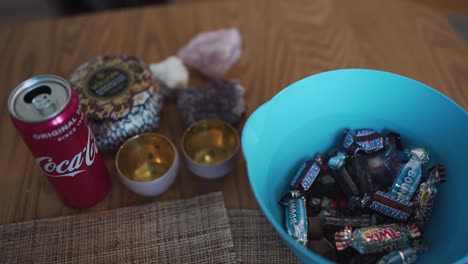 Vista-Panorámica-Que-Va-De-Un-Tazón-Lleno-De-Dulces-A-Una-Coca-Cola