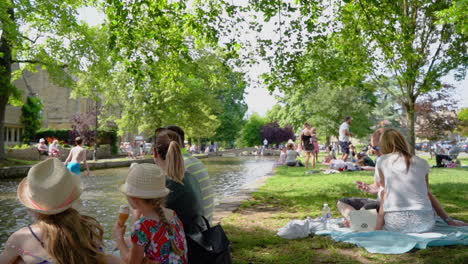 Toma-En-Cámara-Lenta-De-Bourton-on-the-water-En-El-Ajetreado-Y-Caluroso-Verano-Que-Muestra-El-Punto-De-Acceso-Turístico-De-Los-Cotswolds